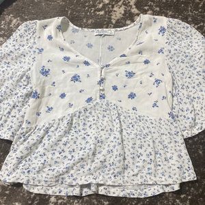 White top with blue floral flowers on it